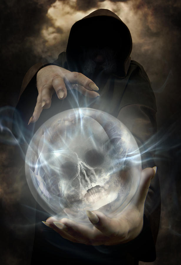 Hooded man wearing dark cloak holding glowing crystall ball with human skull image inside Photograph by Jaroslaw Blaminsky
