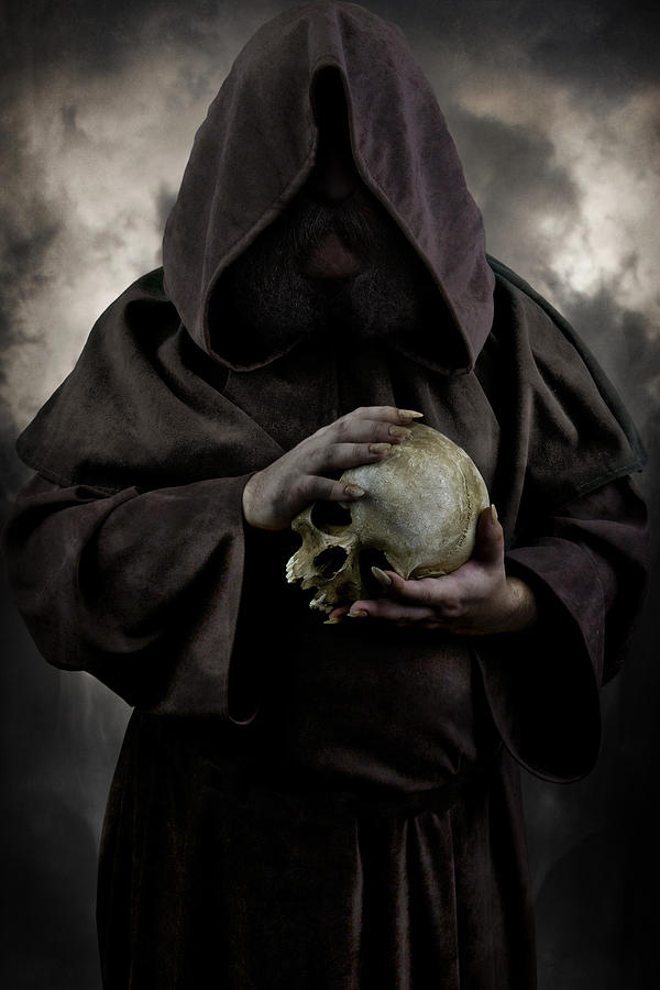 Hooded Moustached Man Wearing Dark Cloak And Holding A Human Skull In