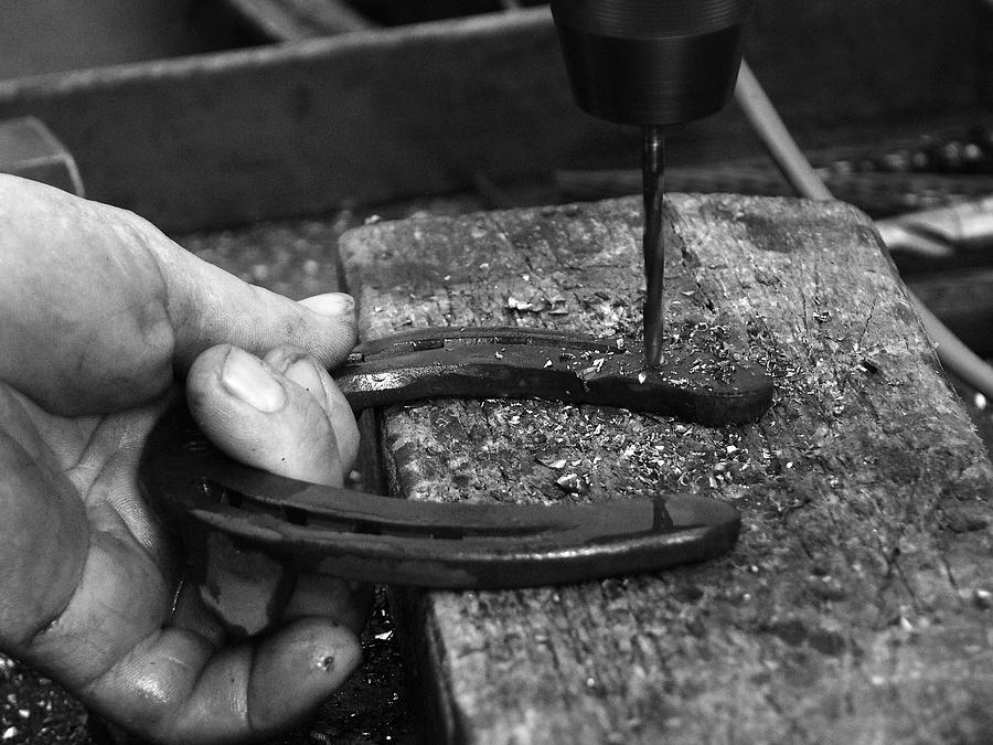 Black And White Photograph - Horseshoe and hand of a blacksmith by Matthias Hauser