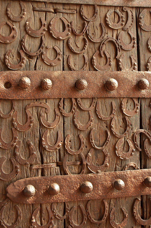 Architecture Photograph - Horseshoes Decorate A Wooden Door, Jama by Inger Hogstrom