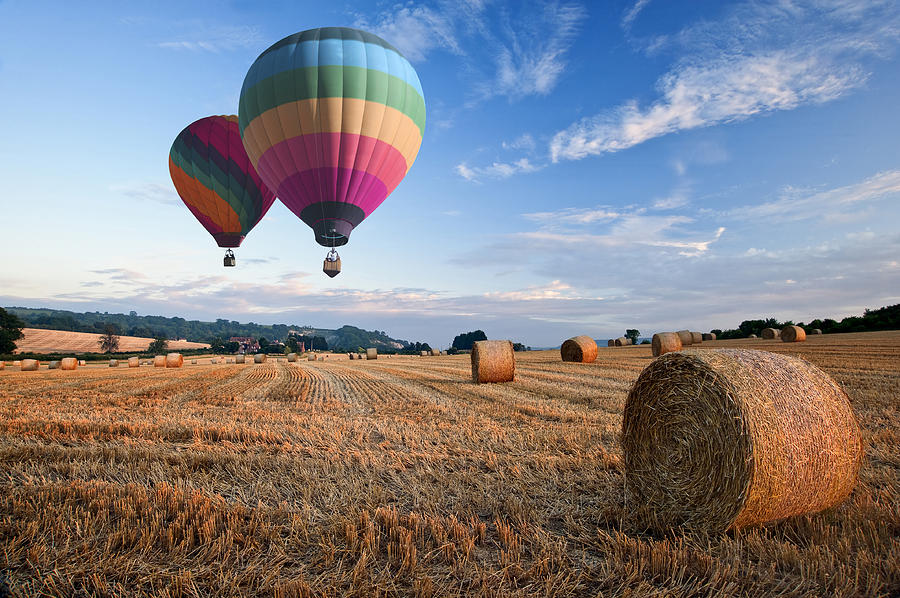 Summer Photograph - Hot air balloons over hay bales sunset landscape by Matthew Gibson