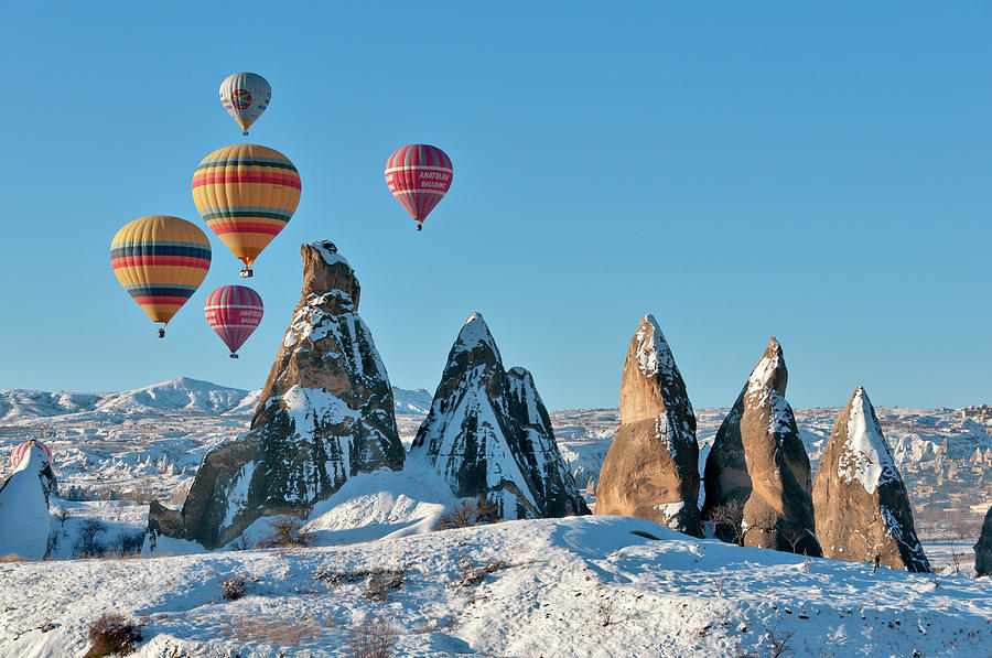 Hot Air Balloons Over Snow Covered Rock Photograph by Izzet Keribar