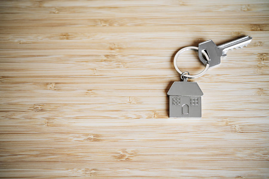 House key on a bamboo table with copy space Photograph by Volanthevist