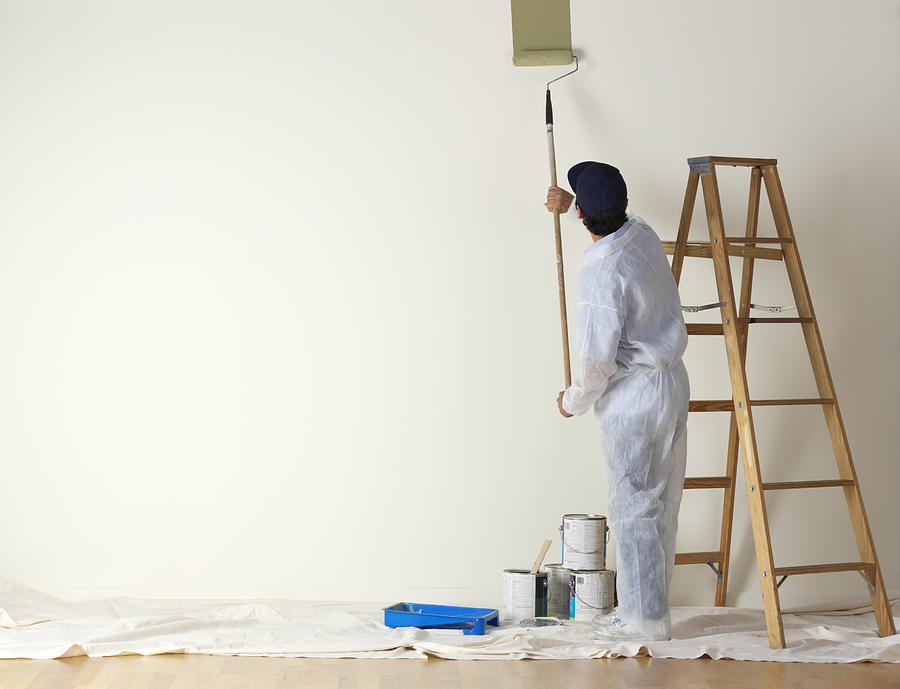House painter beginning to paint a large wall Photograph by Dny59