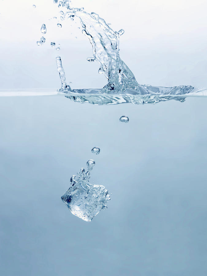 Ice Cube Splashing Into Water Photograph by Ballyscanlon