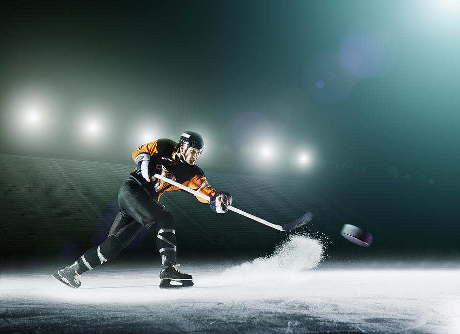 Ice hockey player passing puck. Photograph by Robert Decelis Ltd
