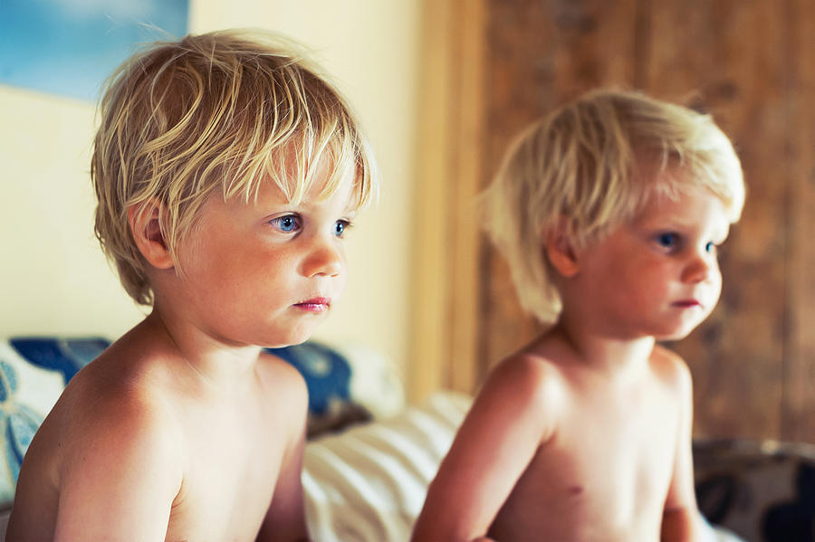 Identical twin blonde boys watching TV Photograph by Alex Linghorn