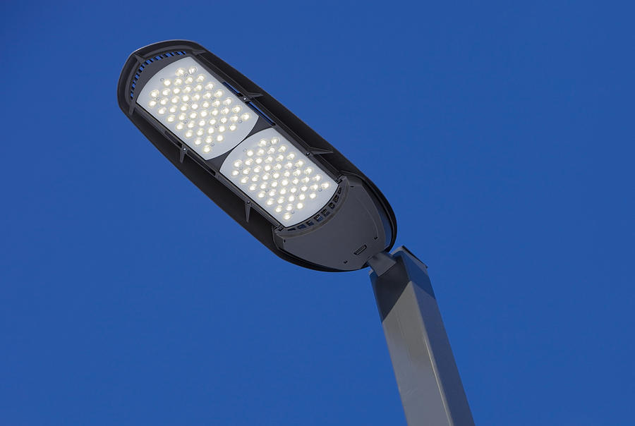 Illuminated LED Streetlight against a Clear Blue Sky Photograph by BanksPhotos