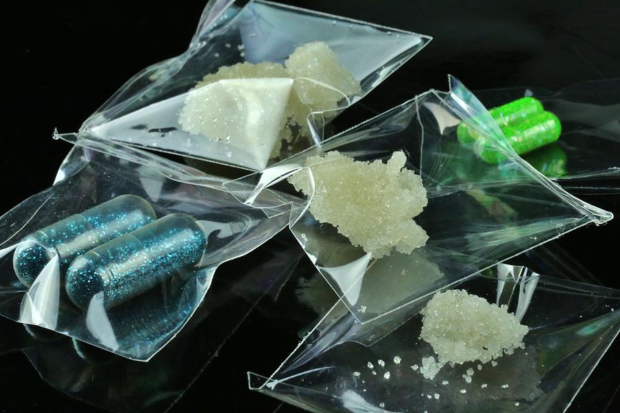 Individual bags of illegal drugs on a black background Photograph by Douglas Sacha