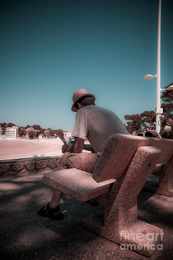 One man sitting on shady bench overlooking b Photograph by Peter Noyce