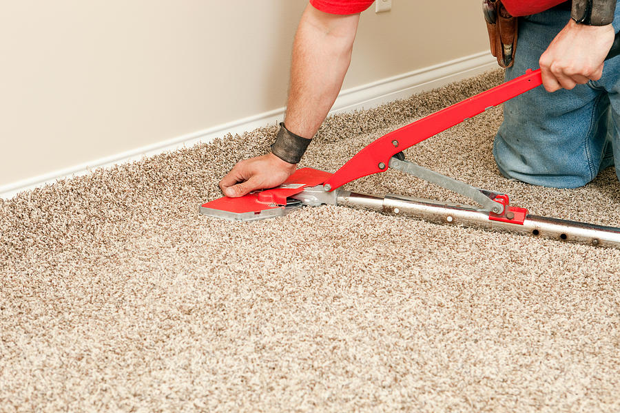 Installer Using Carpet Stretcher on New Bedroom Floor Photograph by BanksPhotos