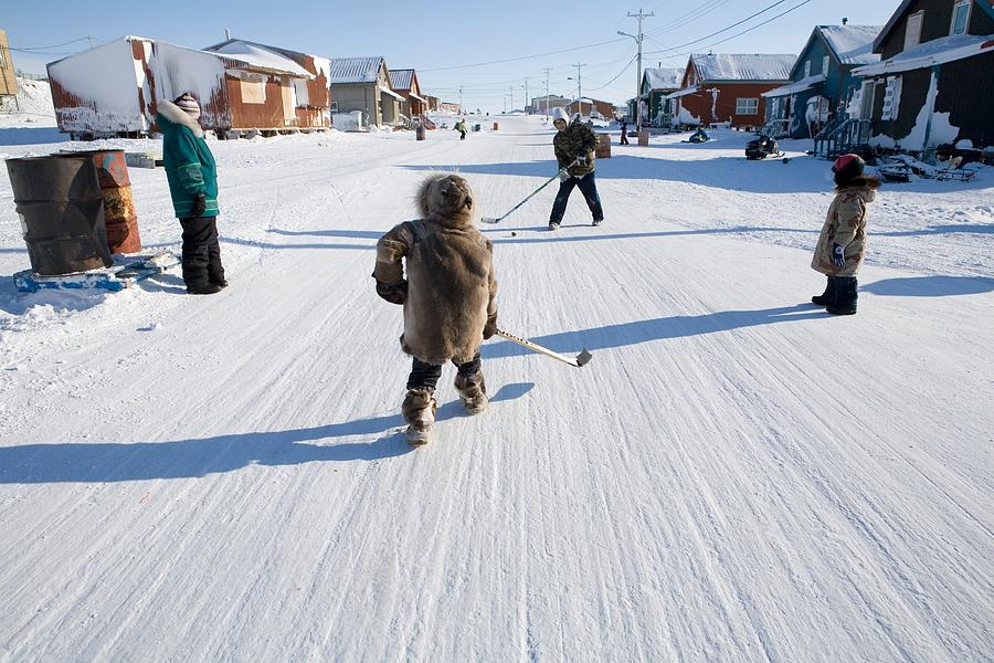 Inuit children playing ice hockey Photograph by Ton Koene photography