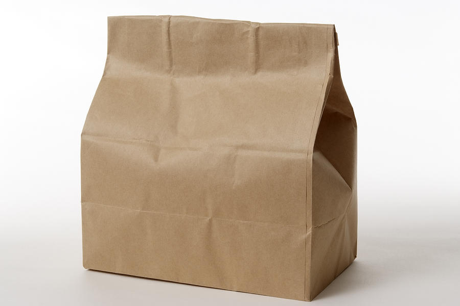 Isolated shot of closed brown paper bag on white background Photograph by Kyoshino