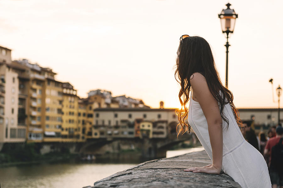Italy, Florence, woman watching sunset behind Ponte Vecchio Photograph by Westend61
