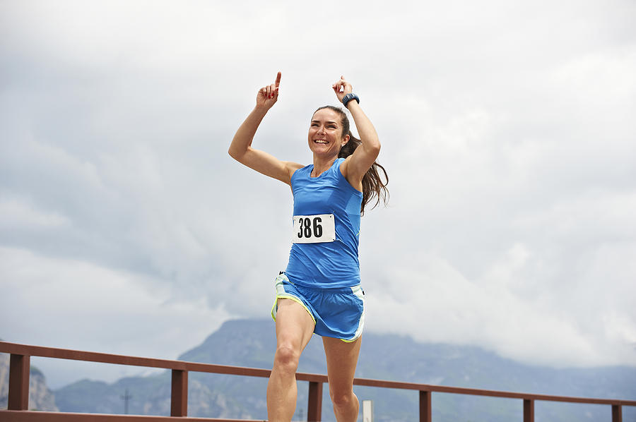 Italy, Trentino, woman winning a running competition near Lake Garda Photograph by Westend61
