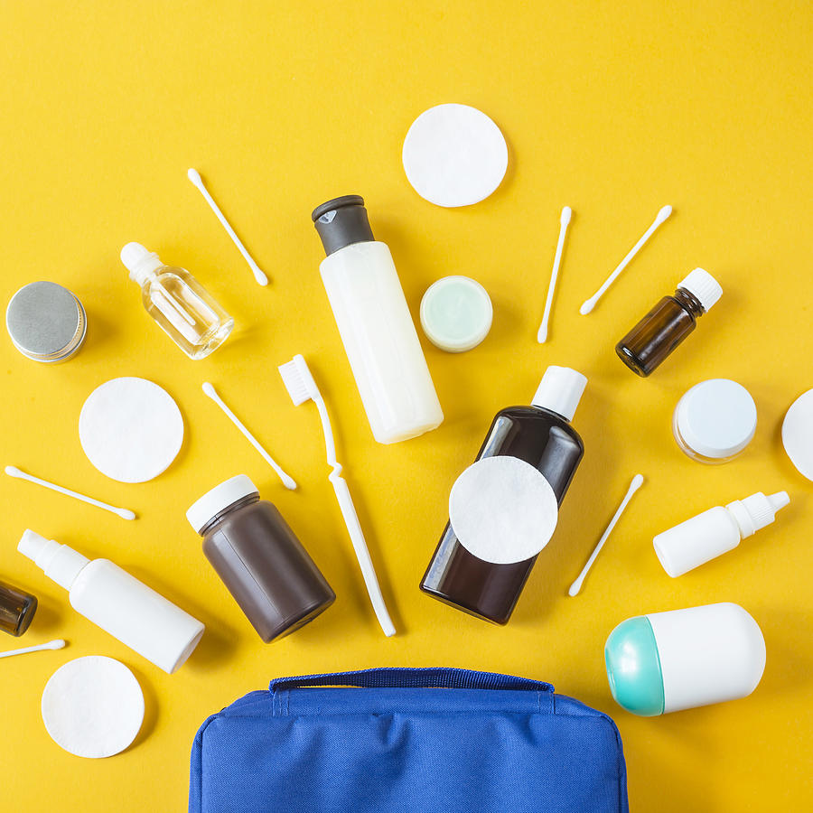 Jars and containers with cosmetics and cotton buds with disks from a blue cosmetic bag on a yellow background. Top view, flat lay Photograph by Undefined Undefined