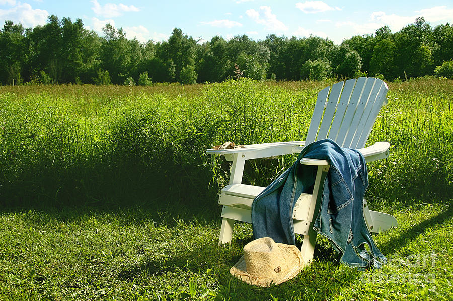 Jeans laying on adirondack chair in field Photograph by Sandra Cunningham