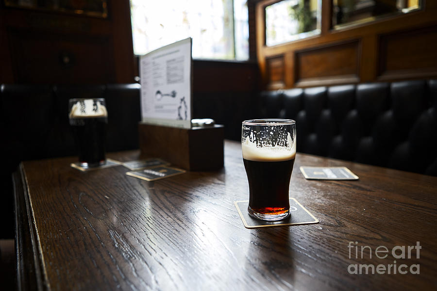 Half Photograph - Joe Fox Fine Art - half drunk pint of guinness in an old irish pub by Joe Fox