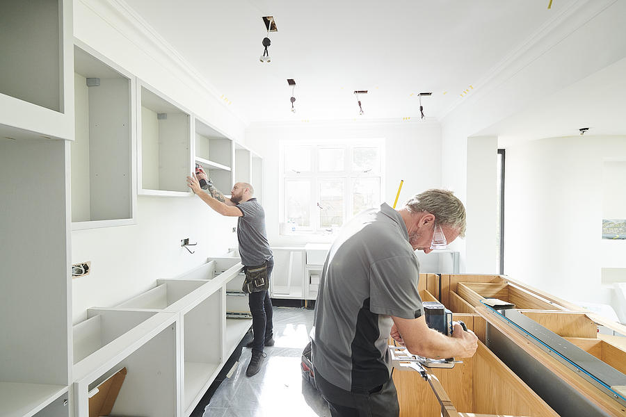 Joinery Team Fitting A Kitchen Photograph by Sturti