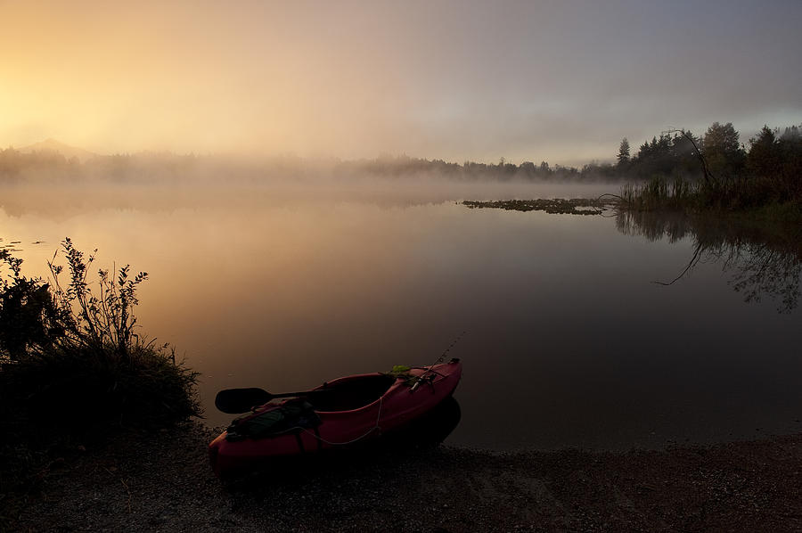 Kayak along shoreline sunrise Lake Cassidy Photograph by Jim Corwin