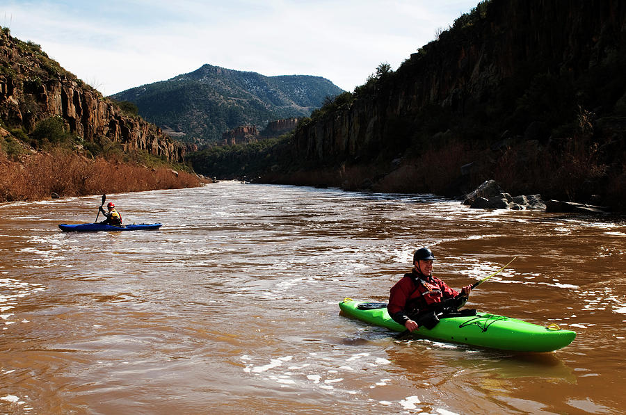 Sports Photograph - Kayakers Paddle Their Boats Downstream by Kyle George