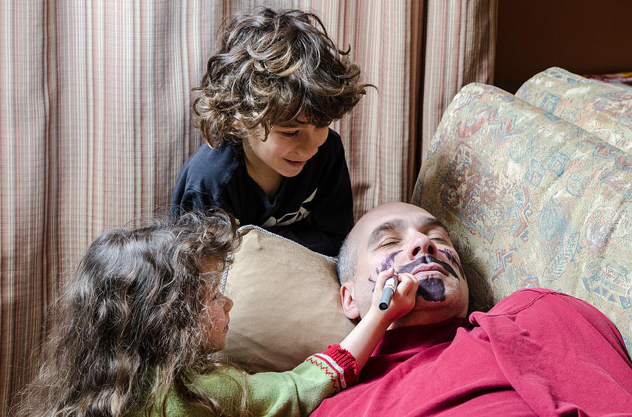 Kids drawing a mustache on fathers face April fools day Photograph by Marcduf