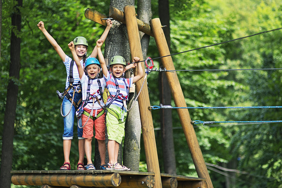 Kids having fun in ropes course adventure park Photograph by Imgorthand
