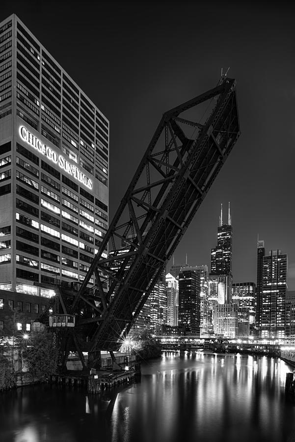 Kinzie Street railroad bridge at night in Black and White Photograph by Sebastian Musial