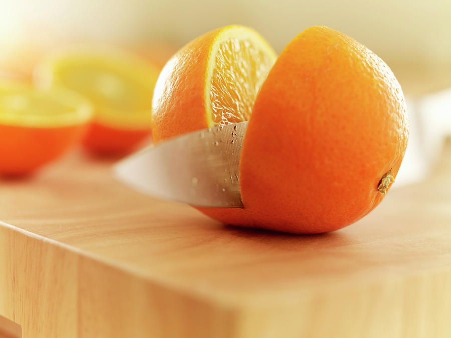 Knife Slicing Orange On Cutting Board Photograph by Adam Gault