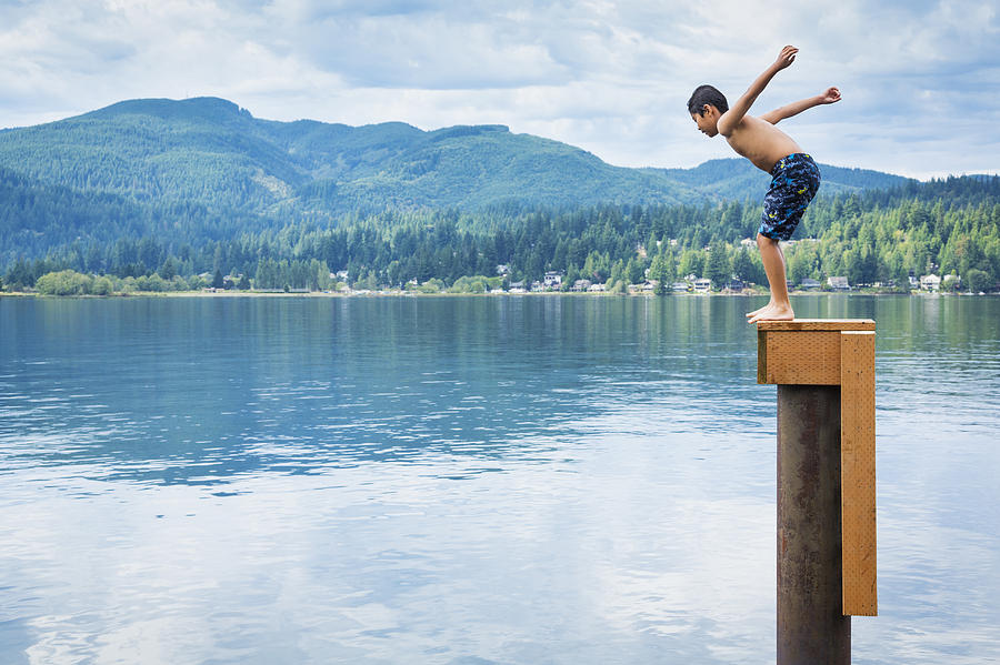Korean boy jumping off platform into lake Photograph by Don Mason