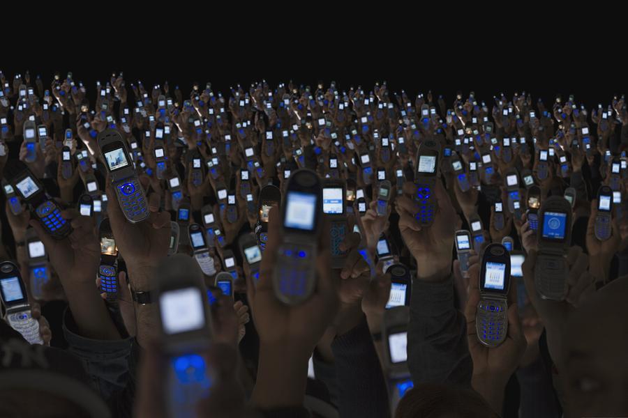 Large group of people holding open cell phones up in air Photograph by Jose Luis Pelaez Inc