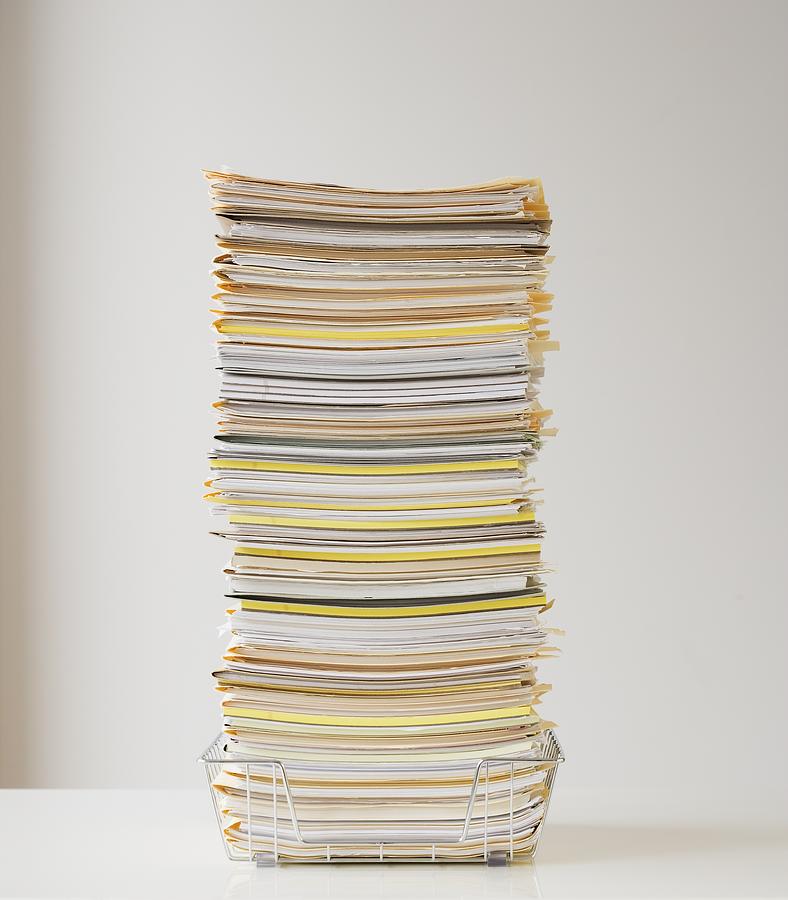 Large stack of paperwork in wire basket Photograph by Tetra Images