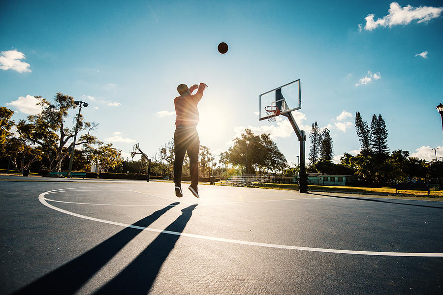 Latino guy shooting basketball on the court in USA in summer Photograph by Drazen_