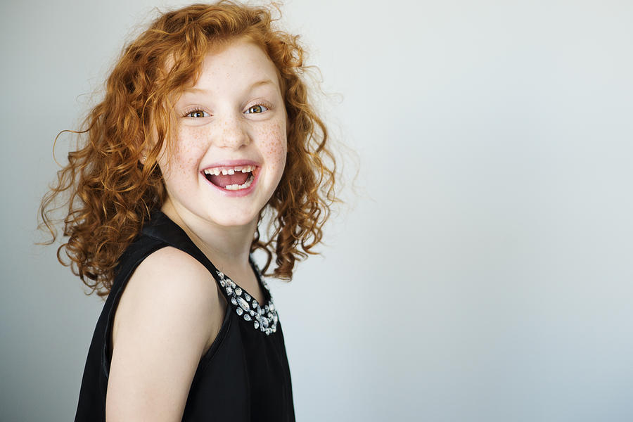 Laughing redhead little girl with freckles and missing tooth. Photograph by Martinedoucet