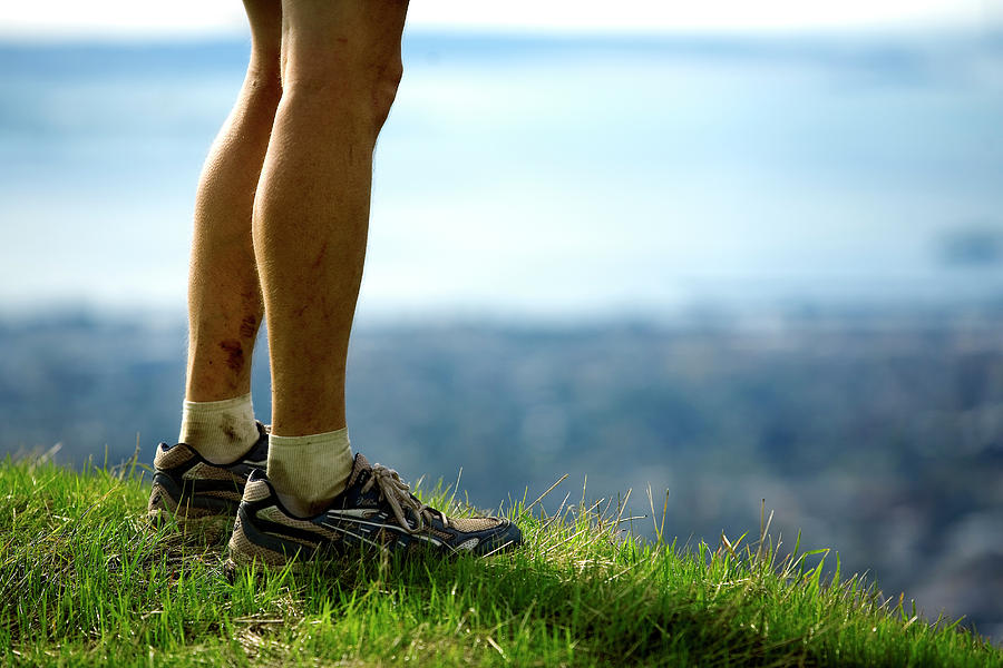 Legs Of A Runner On A Hill Above A City Photograph by Corey Rich