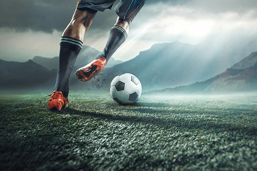 Legs of soccer player kicking the ball Photograph by Anton5146