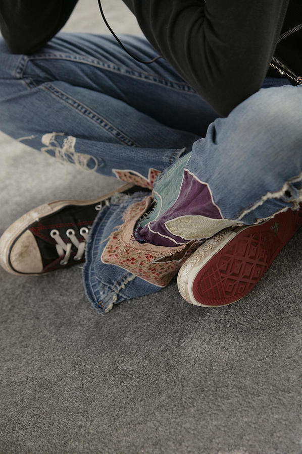 Legs of teenage girl sitting on floor Photograph by Comstock Images