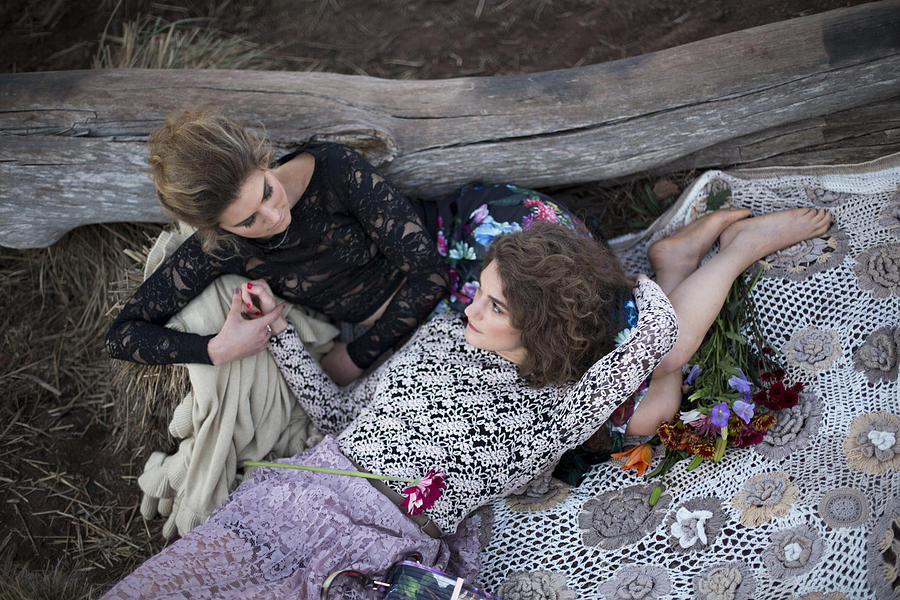 Lesbian couple outdoors on blanket. Photograph by Photography by Braden Summers