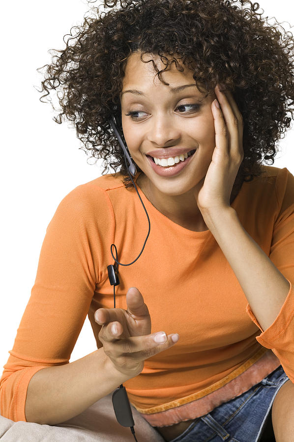Lifestyle Portrait Of A Young Adult Woman In An Orange Shirt As She Talks On A Hands Free Cell Phone System Photograph by Photodisc