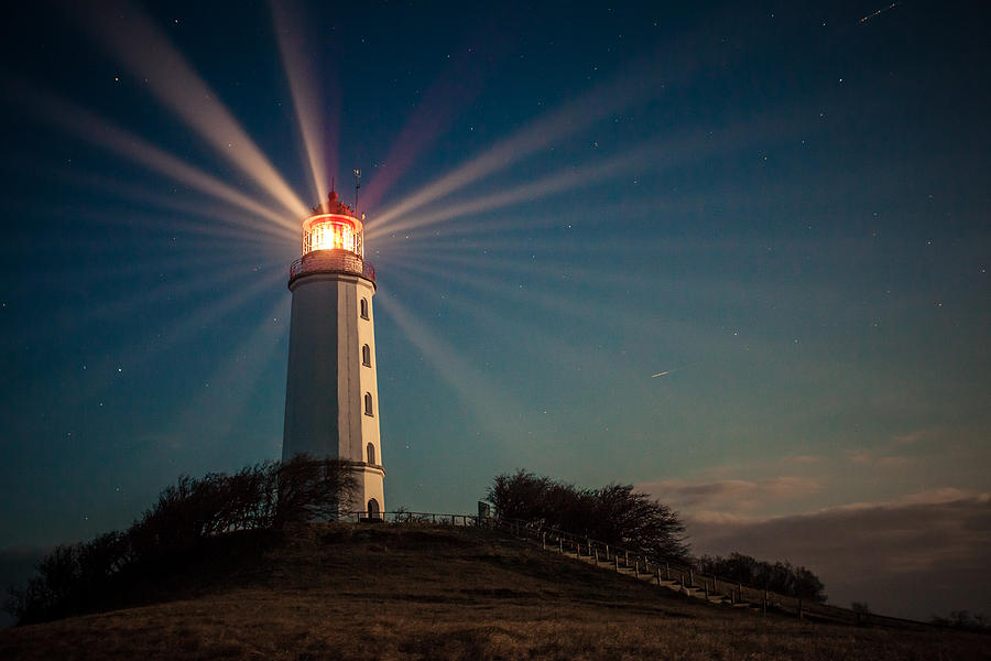 Lighthouse on a hill shining at night Photograph by Daniela Garling