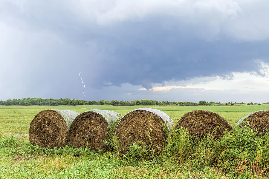 Lightning and round bales Photograph by Rob Graham