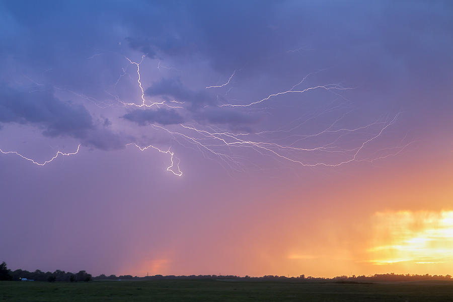 Lightning at sunset Photograph by Rob Graham