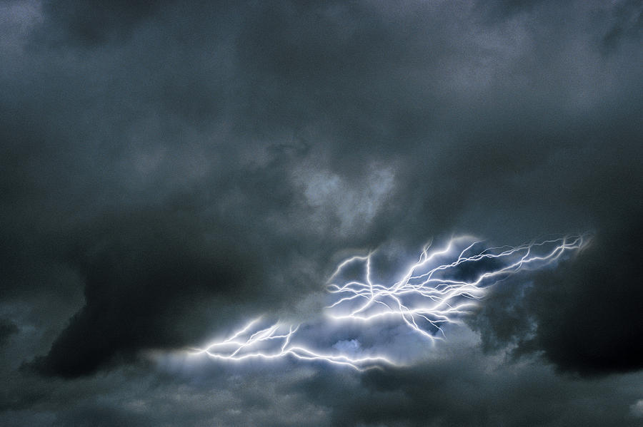 Lightning in a cloudy sky Photograph by Comstock