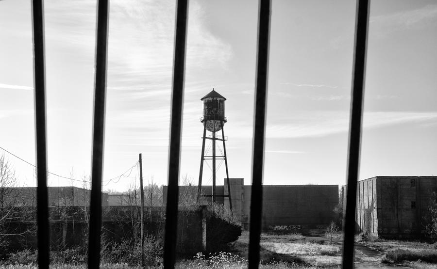 Linfield Industrial Park Water Tower Behind Bars Photograph by Bill Cannon