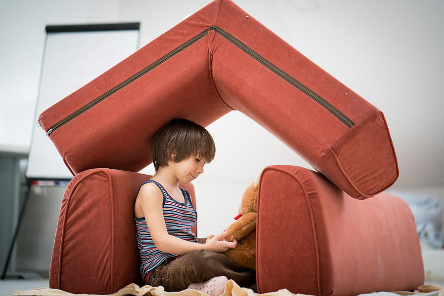 Little boy and Teddy bear with small house made of furniture Photograph by Jasmin Merdan