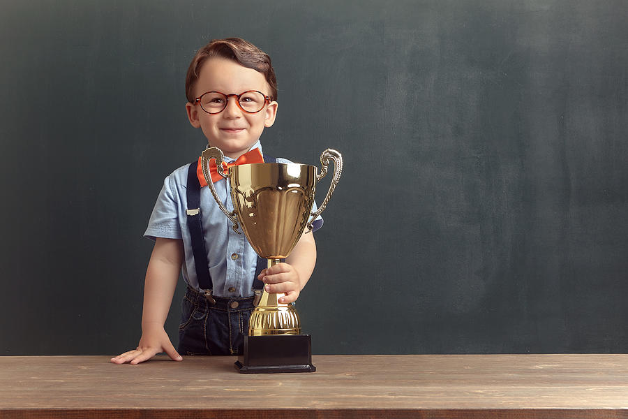 Little boy holding a golden trophy Photograph by Pinstock