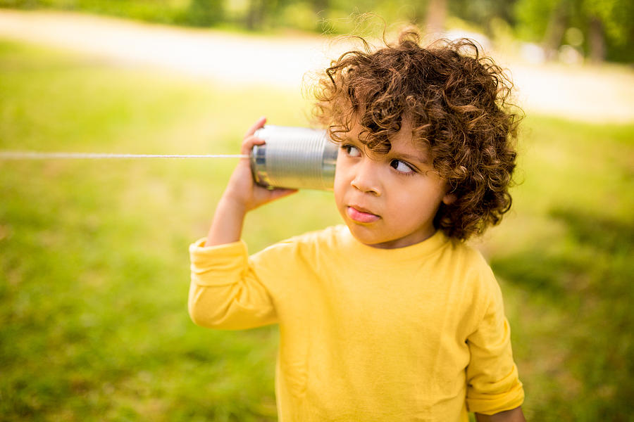 Little boy listening to sound through a tin can phone Photograph by Wundervisuals