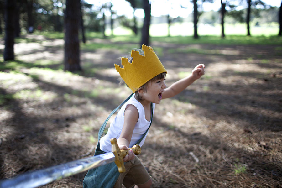 Little boy with crown running in forest with sword Photograph by Wander Women Collective