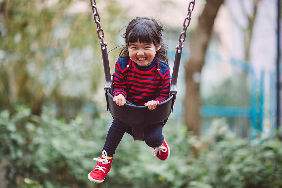 Little girl swinging on the swing joyfully Photograph by images by Tang Ming Tung