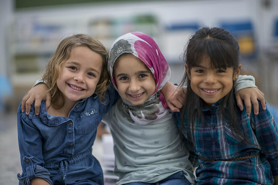 Little Muslim girl and her friends enjoy a day at school together. Photograph by FatCamera
